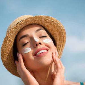 femeie care aplica un produs cu protectie solara