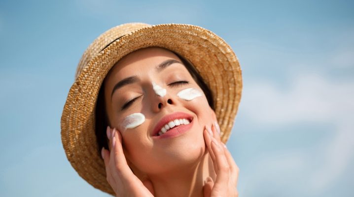 femeie care aplica un produs cu protectie solara